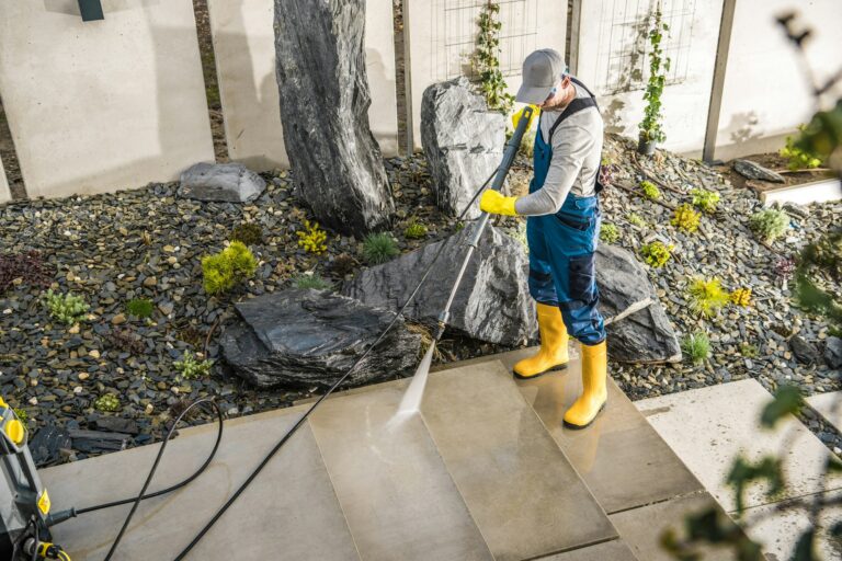 Worker Cleaning the Yard Around the House